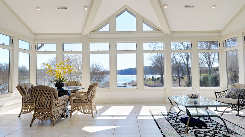 a sunroom with a lake view