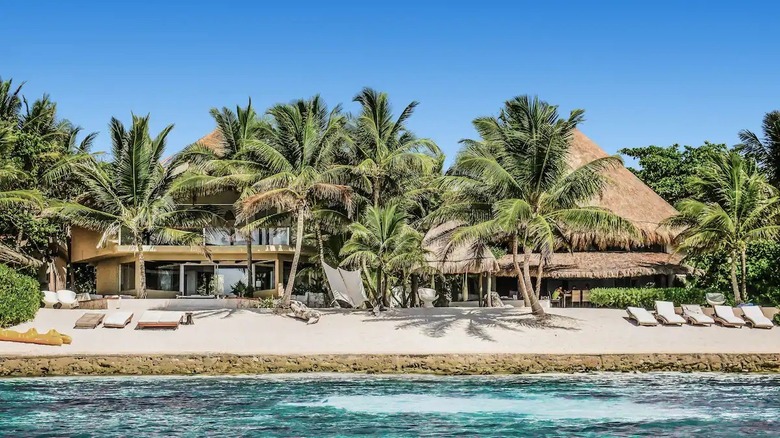 grass roof mansion with palmtrees