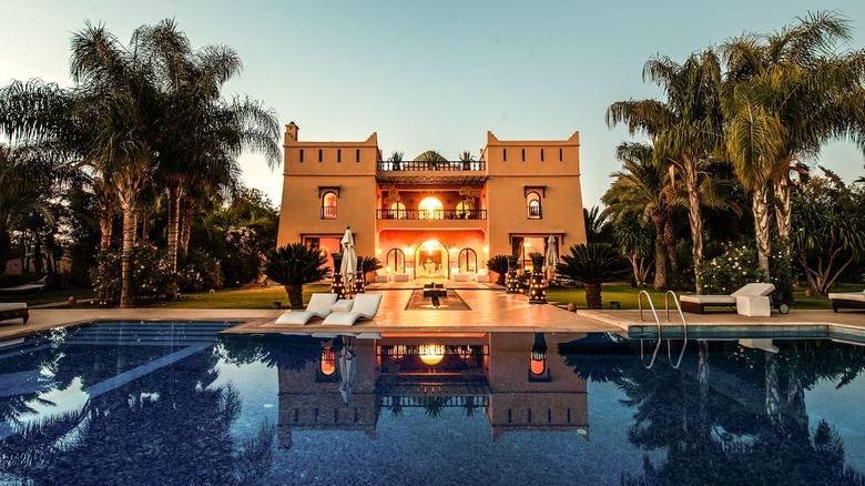 lit-up mansion with a pool