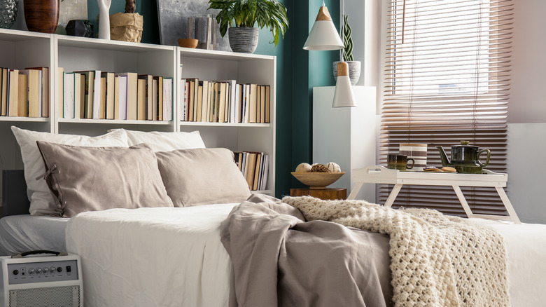 books on a shelf behind a bed