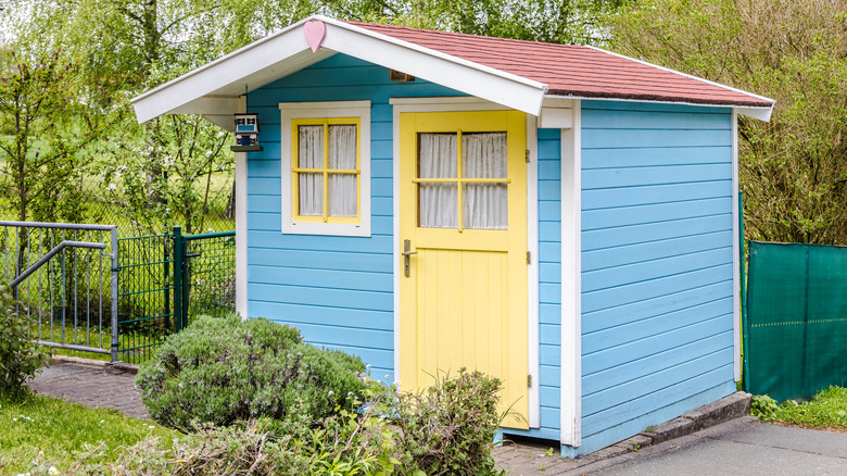 light blue shed with yellow door 