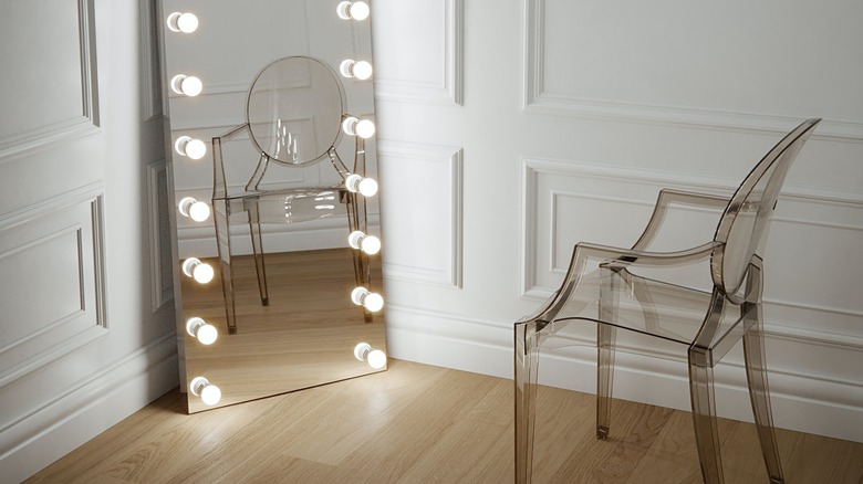 Translucent chair facing lighted mirror