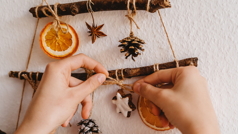 person tying ornaments to sticks