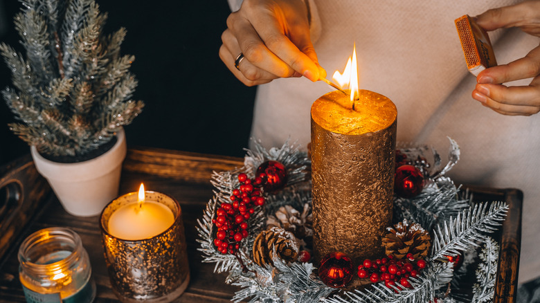 person lighting candle in wreath