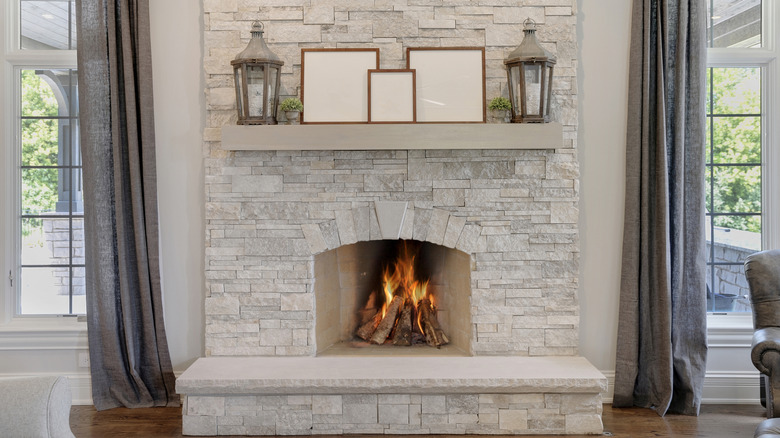 Light natural stone fireplace with fire