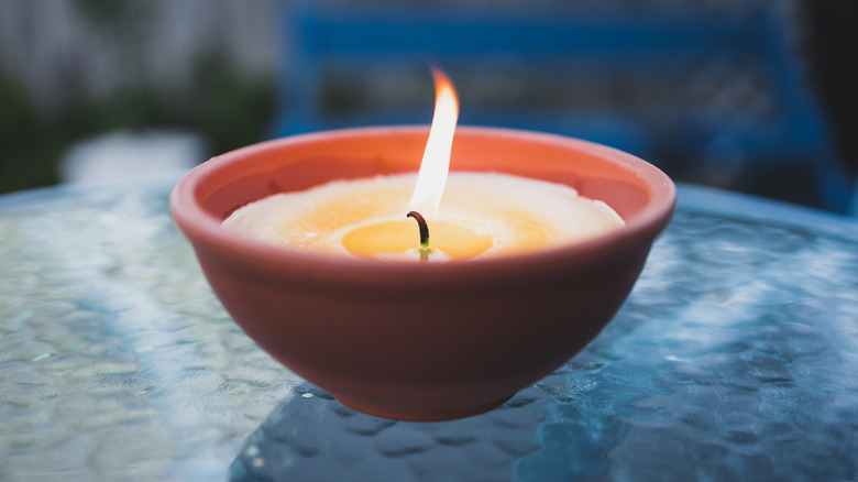 citronella candle with flame outdoor on cafe table