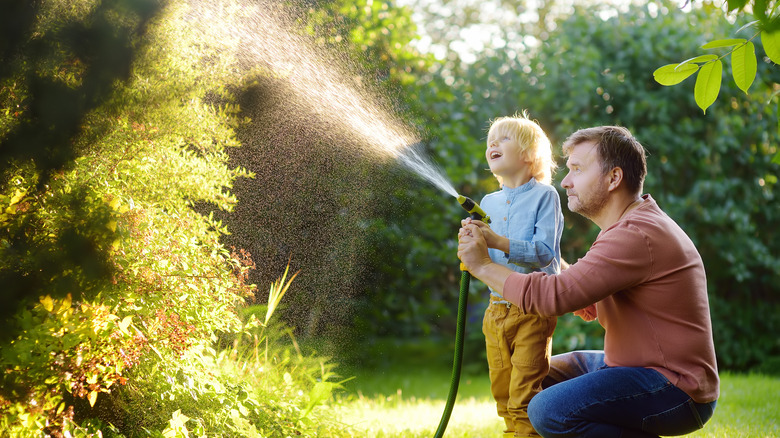 Child and adult spraying water