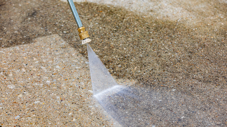 Person power washing concrete