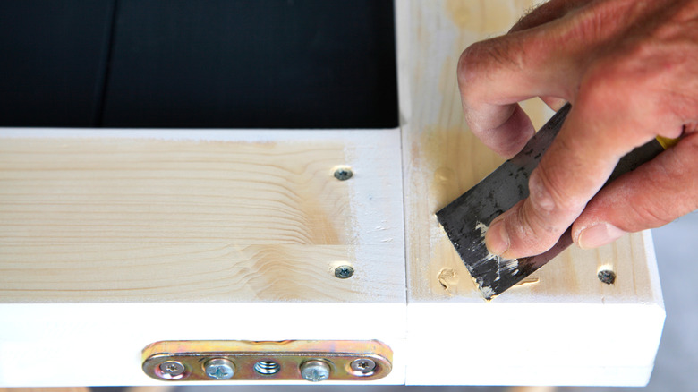 Person filling wood holes