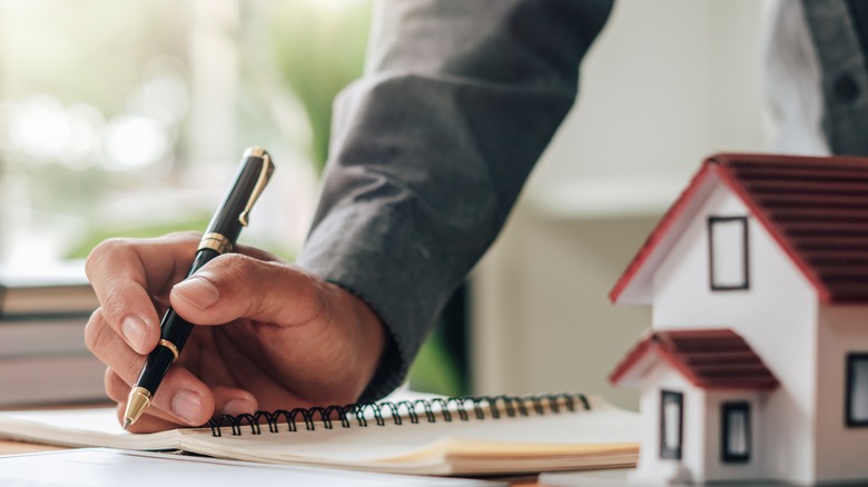 Man's hand writing in notebook