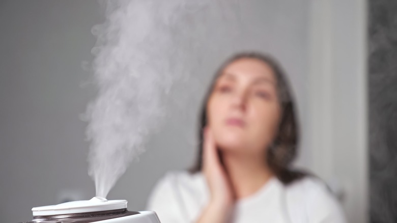 woman moisturizing skin with humidifier