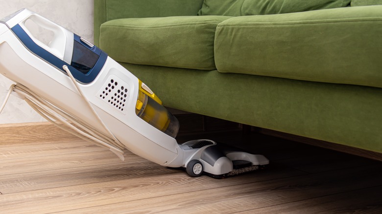 Vacuuming under sofa