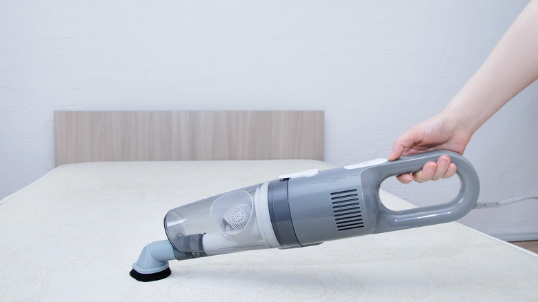 handheld vacuum on white mattress