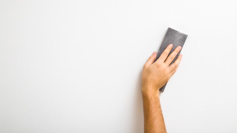 hand sanding a wall