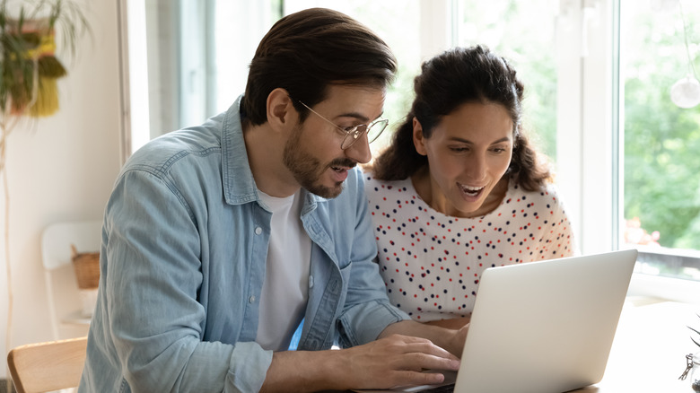 Couple searching on laptop