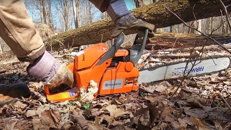 Person starting a Husqvarna chainsaw