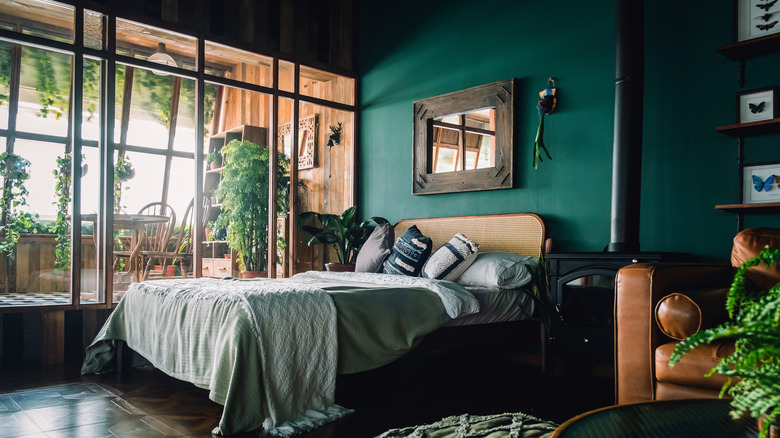 A bedroom with forest green walls and ceiling