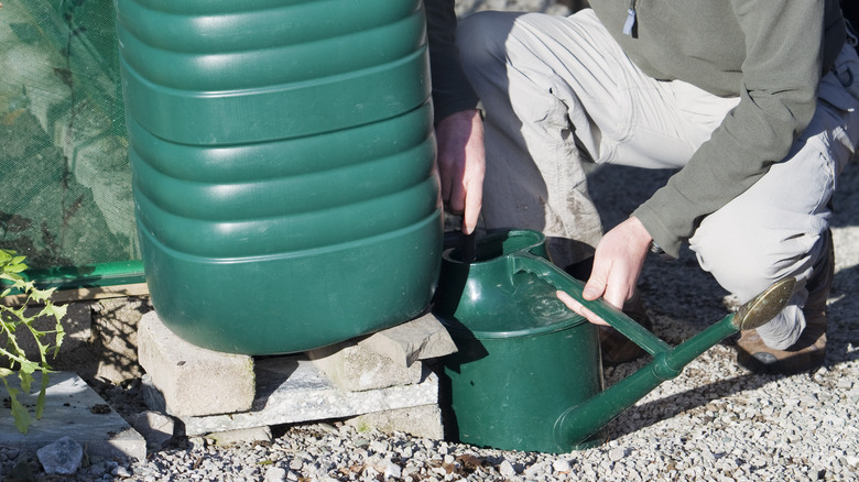 man filling can from barrel