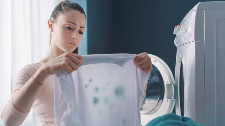 Woman holding up stained laundry