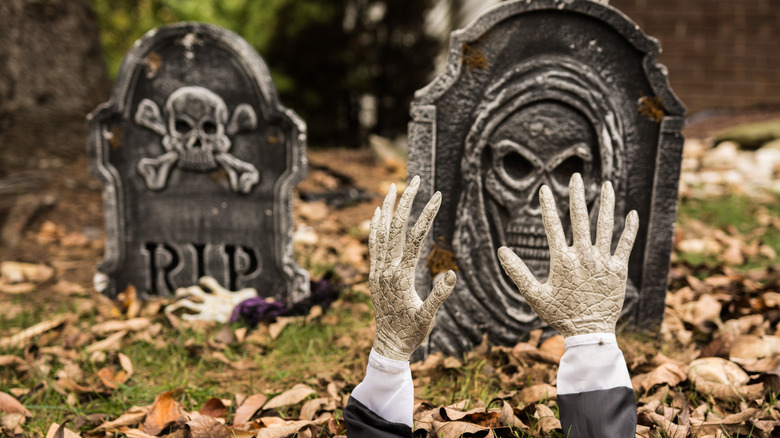 gray tombstones and hands