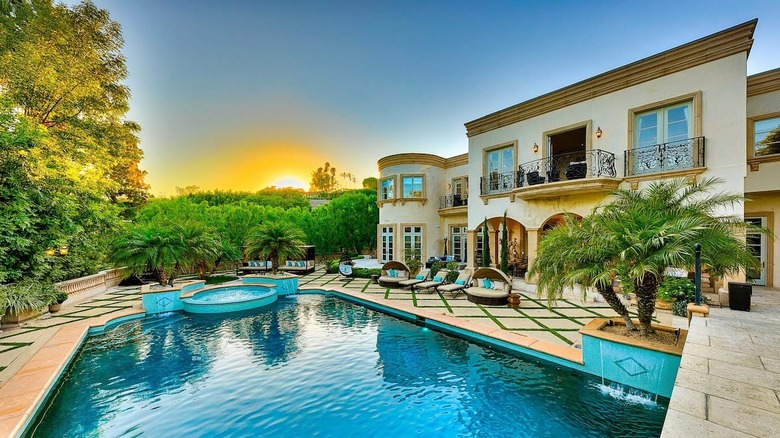 mansion with pool during sunset