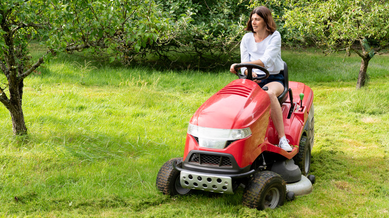 Woman on riding lawnmower