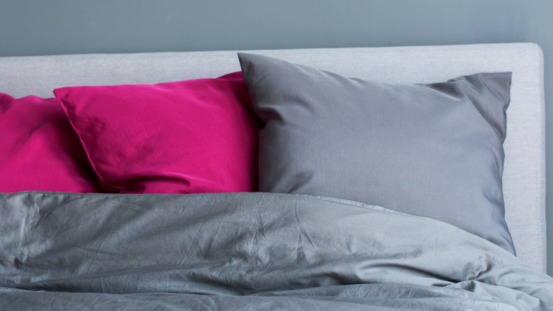 fuchsia pillows in gray bed