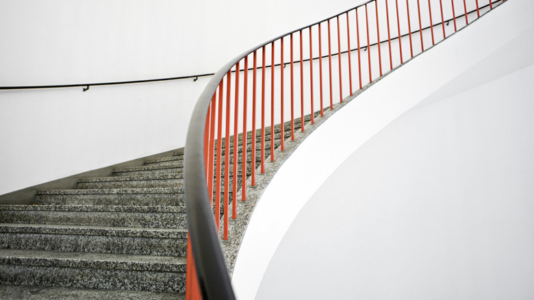 Curved stairs with red banister