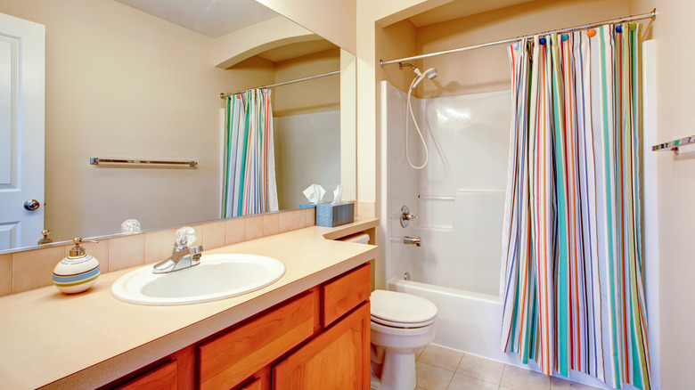 bathroom with bright striped curtain