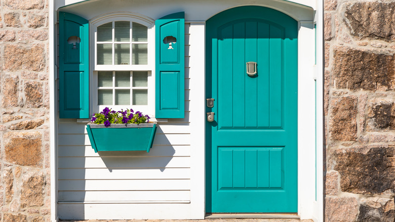 white cottage with teal shutters 