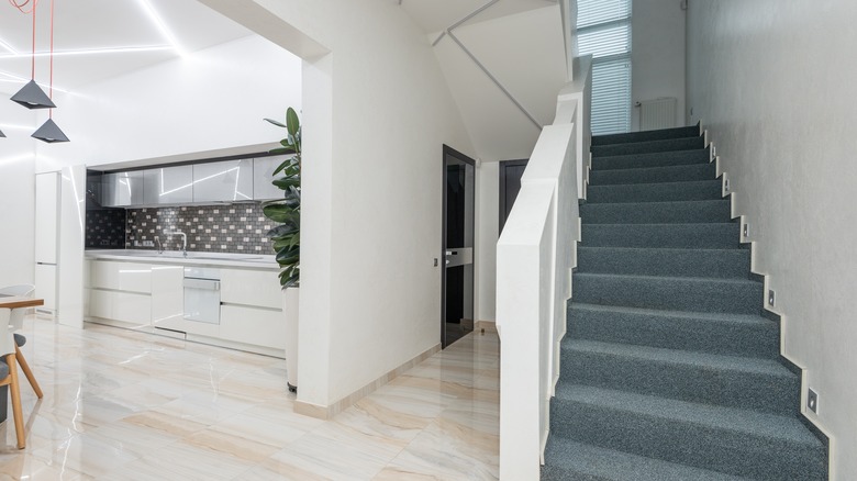 hallway with carpeted stairs