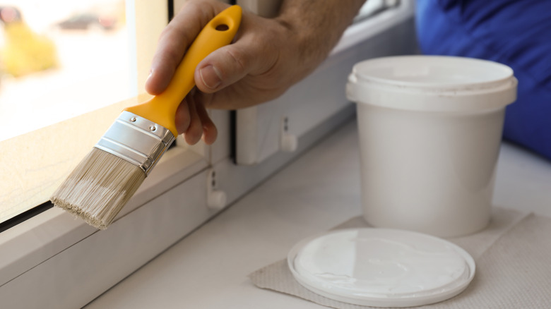 person painting window trim