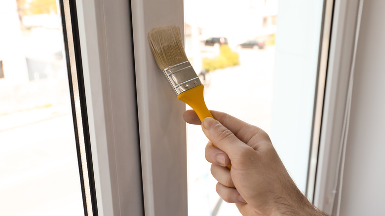 person painting window trim