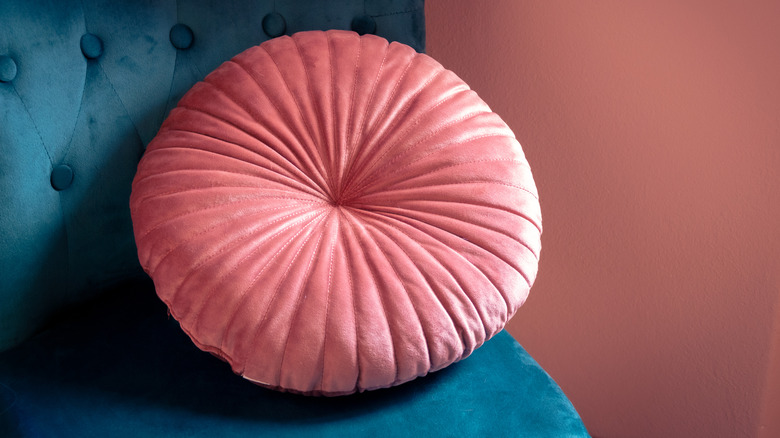 teal chair with pink pillow