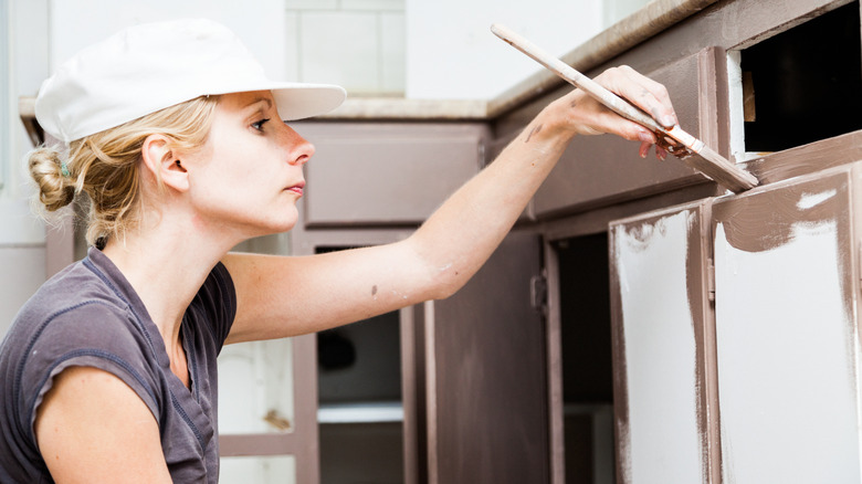 woman painting kitchen cabinets