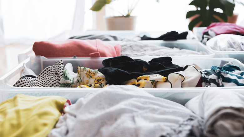 Pieces of clothing in open clear plastic tubs