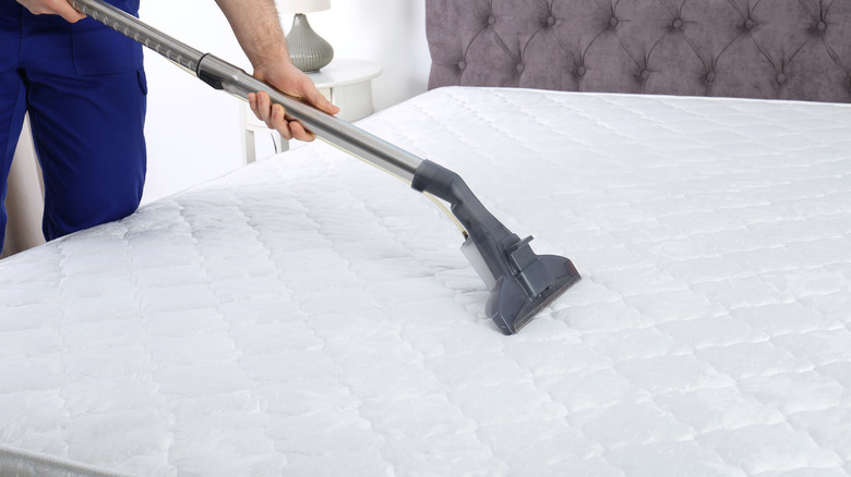 Person vacuuming mattress