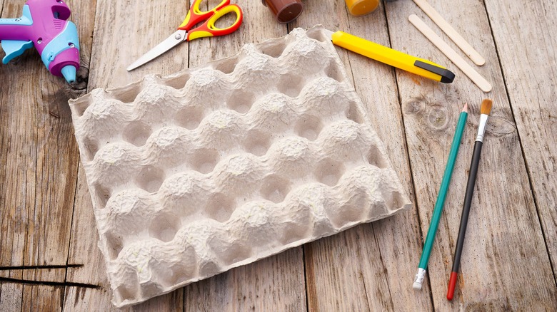 child cutting cardboard egg tray