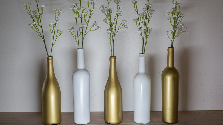 wine bottles holding flowers