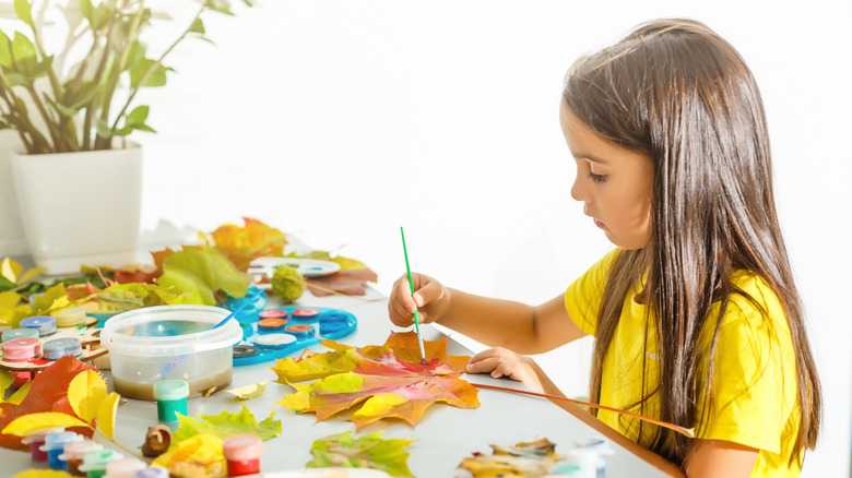 child painting leaves