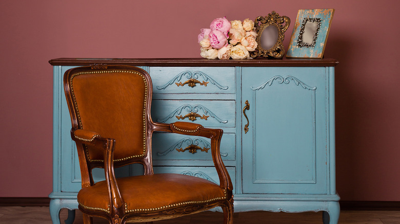 blue dresser behind leather chair