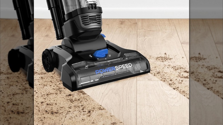 A Eureka Power Speed vacuum cleans a dirty hardwood floor