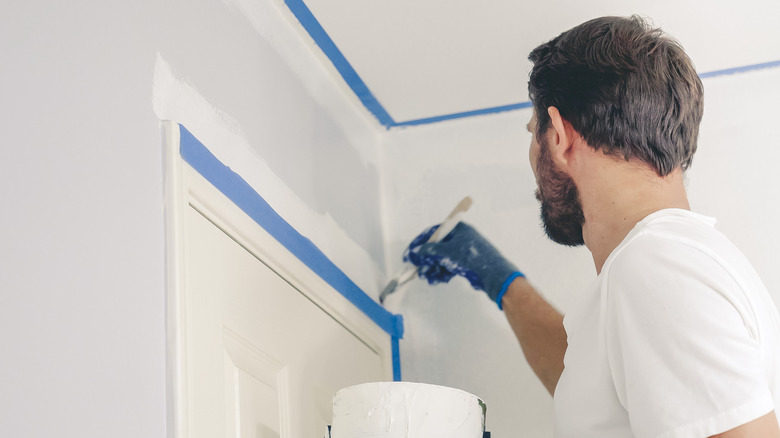 Man painting wall with angled brush