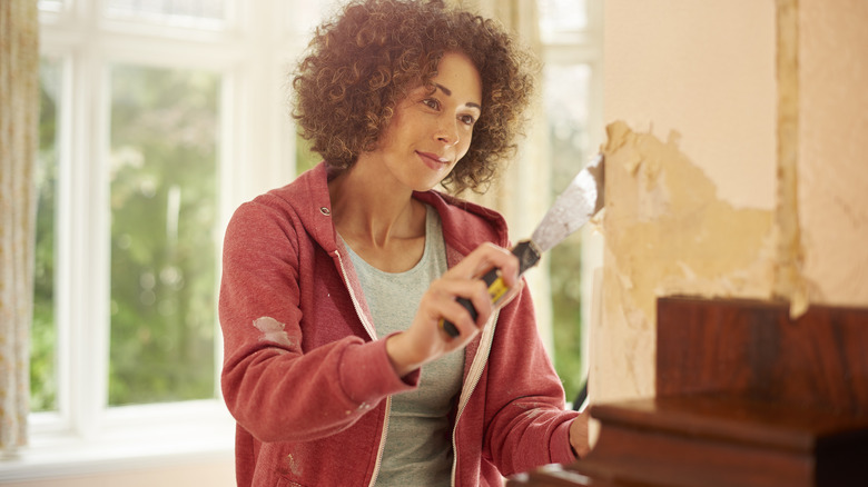 Woman scraping wall clean