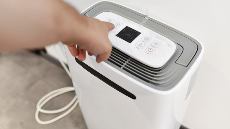 Hand turning on a dehumidifier