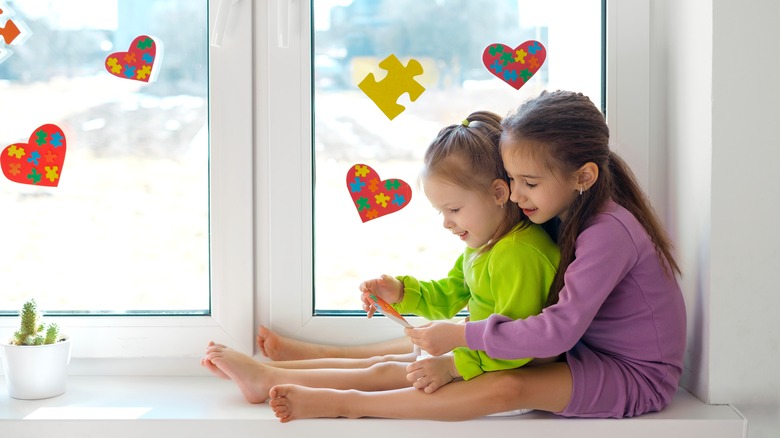 children sitting in window sill