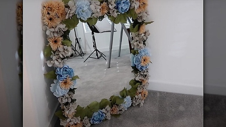 Flowers surrounding mirror on floor