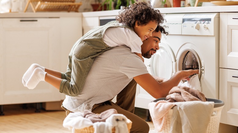 Father and child loading laundry