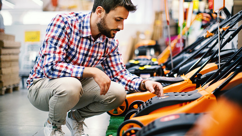 man shopping for lawn mower