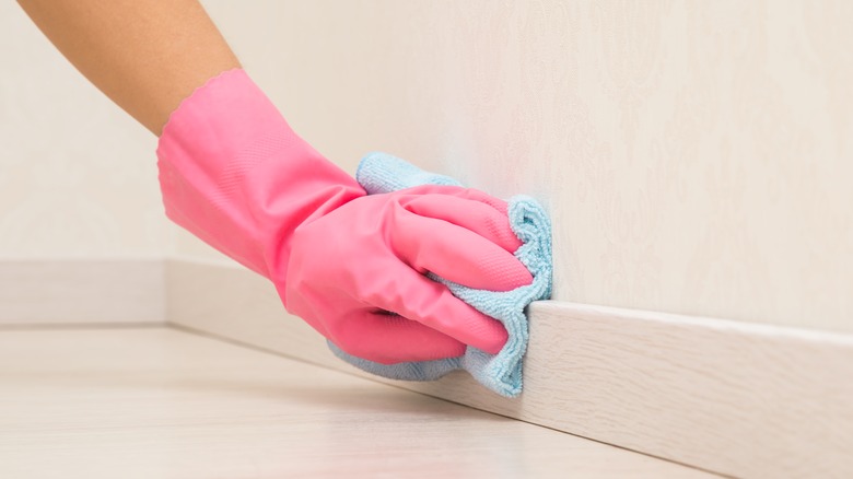 Hand wiping baseboards